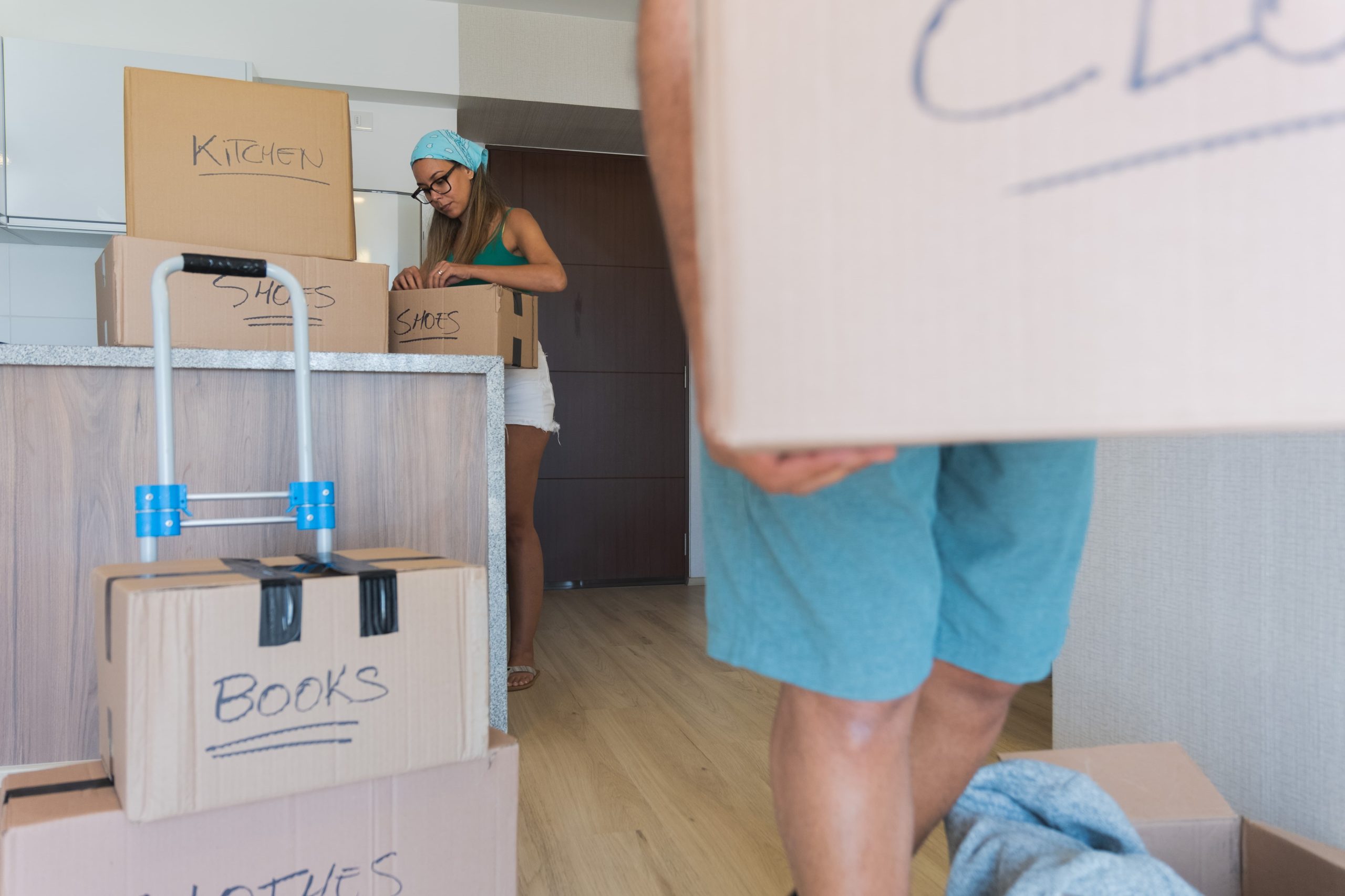 una chica vestida de verano empaquetando cajas en la cocina