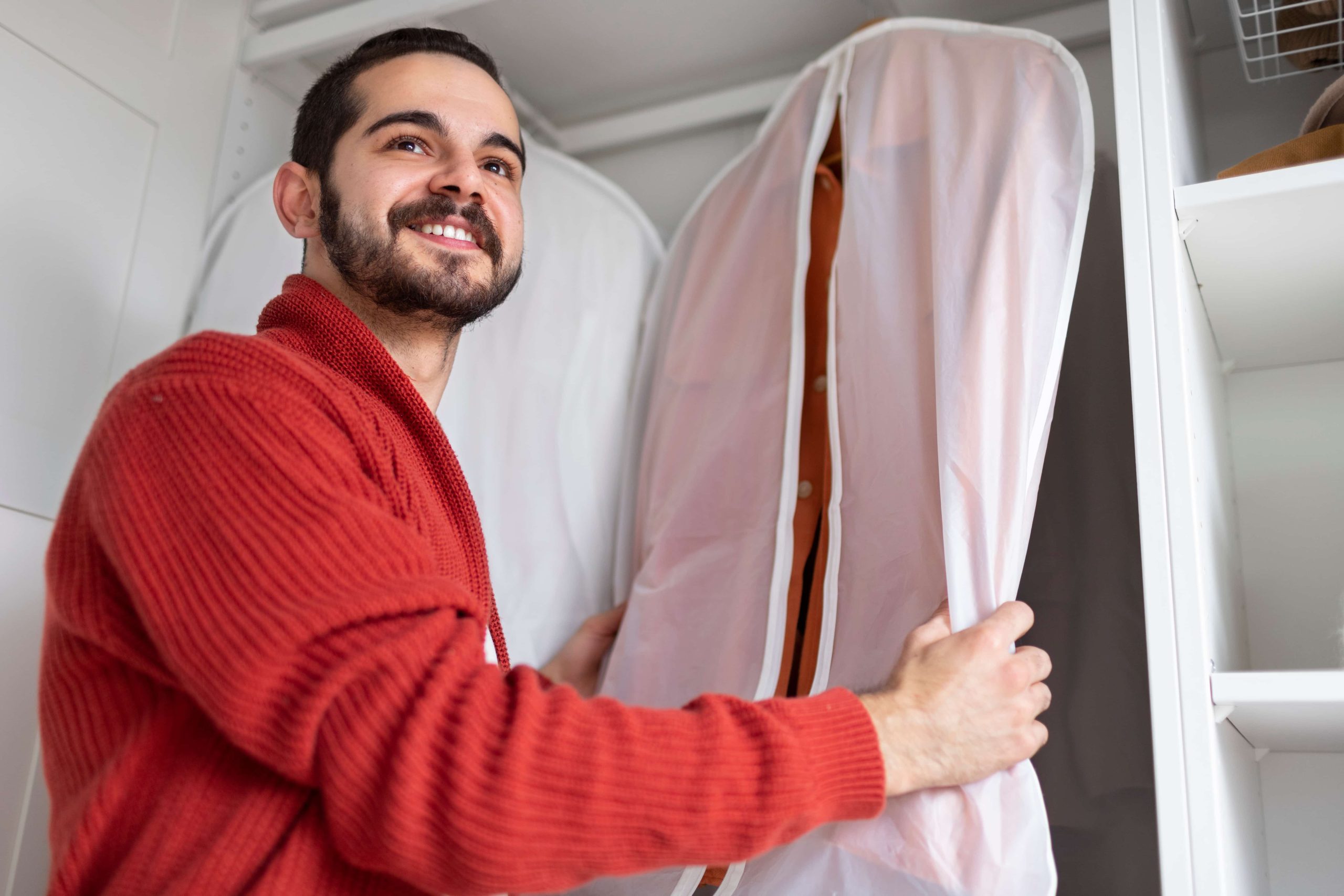 Chico preparando la ropa para la mudanza, poniendo la ropa en una funda.