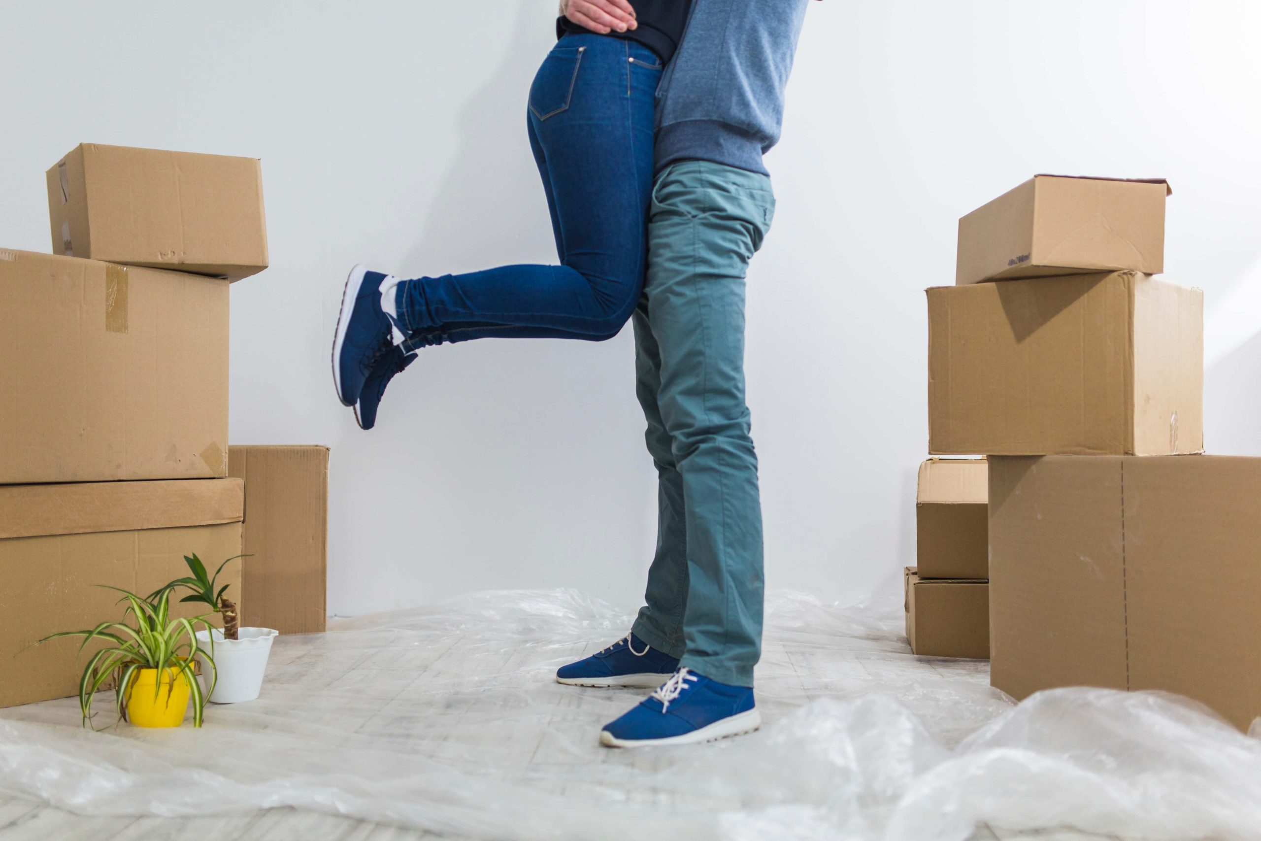 Imagen de una habitación con el suelo cubierto con film para protegerlo con cajas de mudanzas